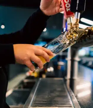 A person pours beer from a tap into a glass at Silverwood’s Golf & Lounge bar in Kanata.