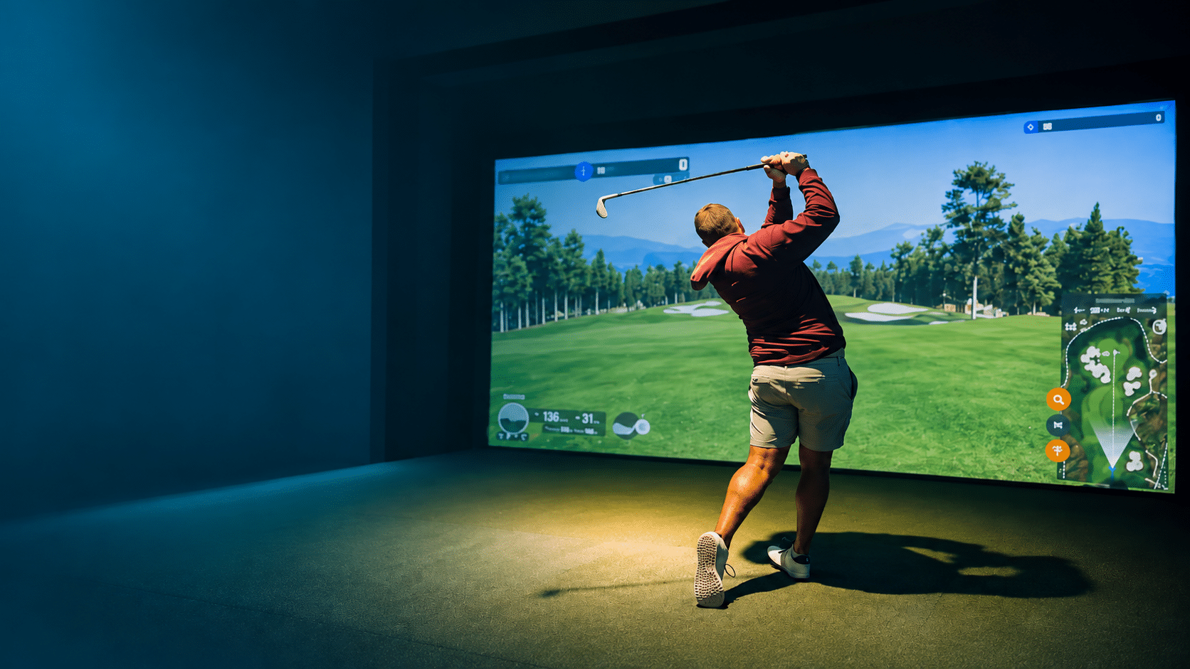 Golfer swinging at a TrackMan simulator in Silverwood’s Golf & Lounge, Kanata.